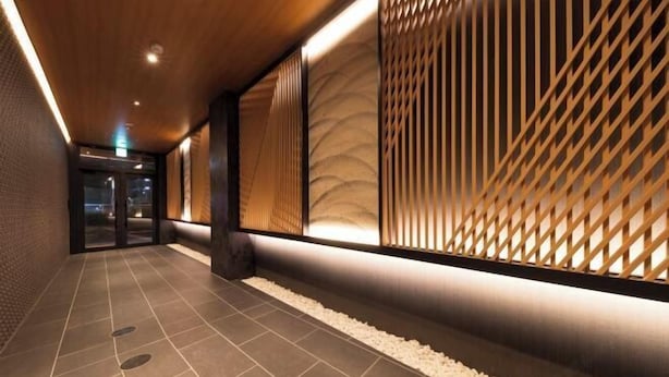 A hallway with a wooden ceiling, textured walls, and a patterned floor. - Shirakabanoyado - Ebisu (Osaka)