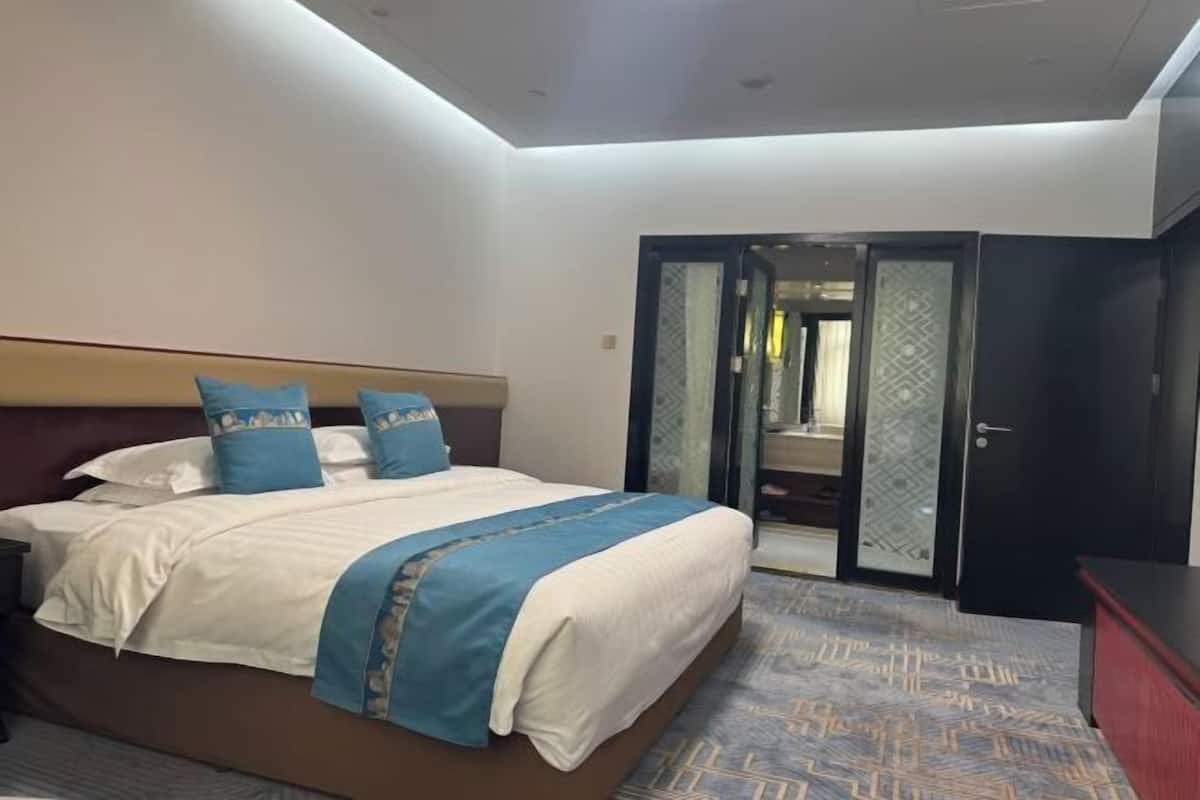 Habitació d'hotel amb llit, escriptori i armari.