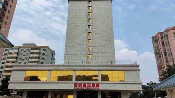 Un edificio de hotel con una estructura vertical destacada y una entrada horizontal.