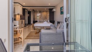 Une chambre d’hôtel moderne équipée d’un lit, d’un canapé, d’une table à manger et d’un coin cuisine.