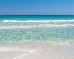 Une plage à l’eau turquoise et au sable blanc.