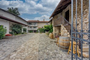 Stroll through the charming courtyard, surrounded by a stone facade and a balcony offering a view of the area.