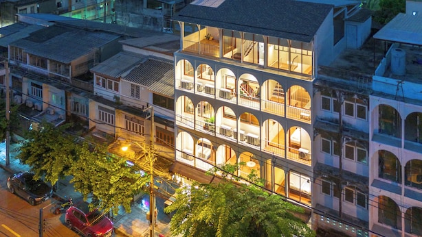 Un edificio de varios pisos con un patio central, rodeado por otras construcciones.