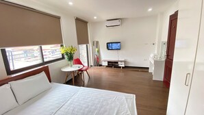 A hotel room with a bed, a TV, a desk, and a chair.