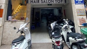 A hair salon with a sign reading "HAIR SALON TOP" and a blue sign with the number "18" and "ERA LA THANH SÒ 18".
