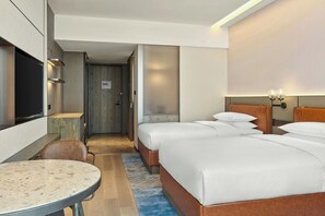 A hotel room with a bed, bedside tables, a TV, and a seating area. - Four Points by Sheraton Changzhou Economic Development Zone (Changzhou)
