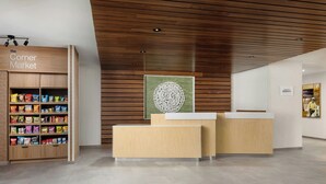 A clean, modern reception area with a wooden reception desk and a snack display. - Fairfield by Marriott Inn & Suites Union (Union)