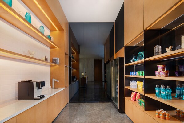 A modern kitchen with a coffee machine, shelves with various items, and a refrigerator. - Fairfield by Marriott Zhoushan Putuo (Zhoushan)