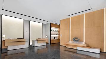 Una zona de recepción moderna con un mostrador de mármol, un mostrador de madera y una exhibición de objetos decorativos.