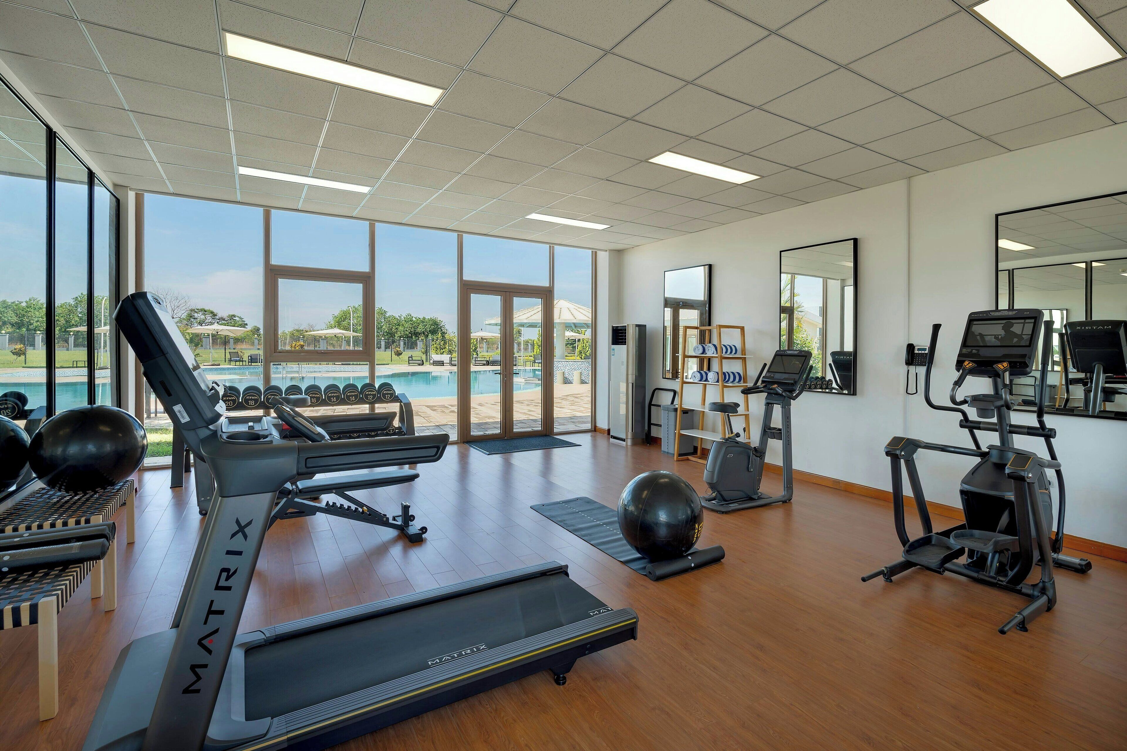 A gym with treadmills, elliptical machines, and free weights.