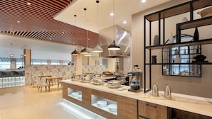 A modern kitchen with a central island, pendant lighting, and a variety of kitchenware.