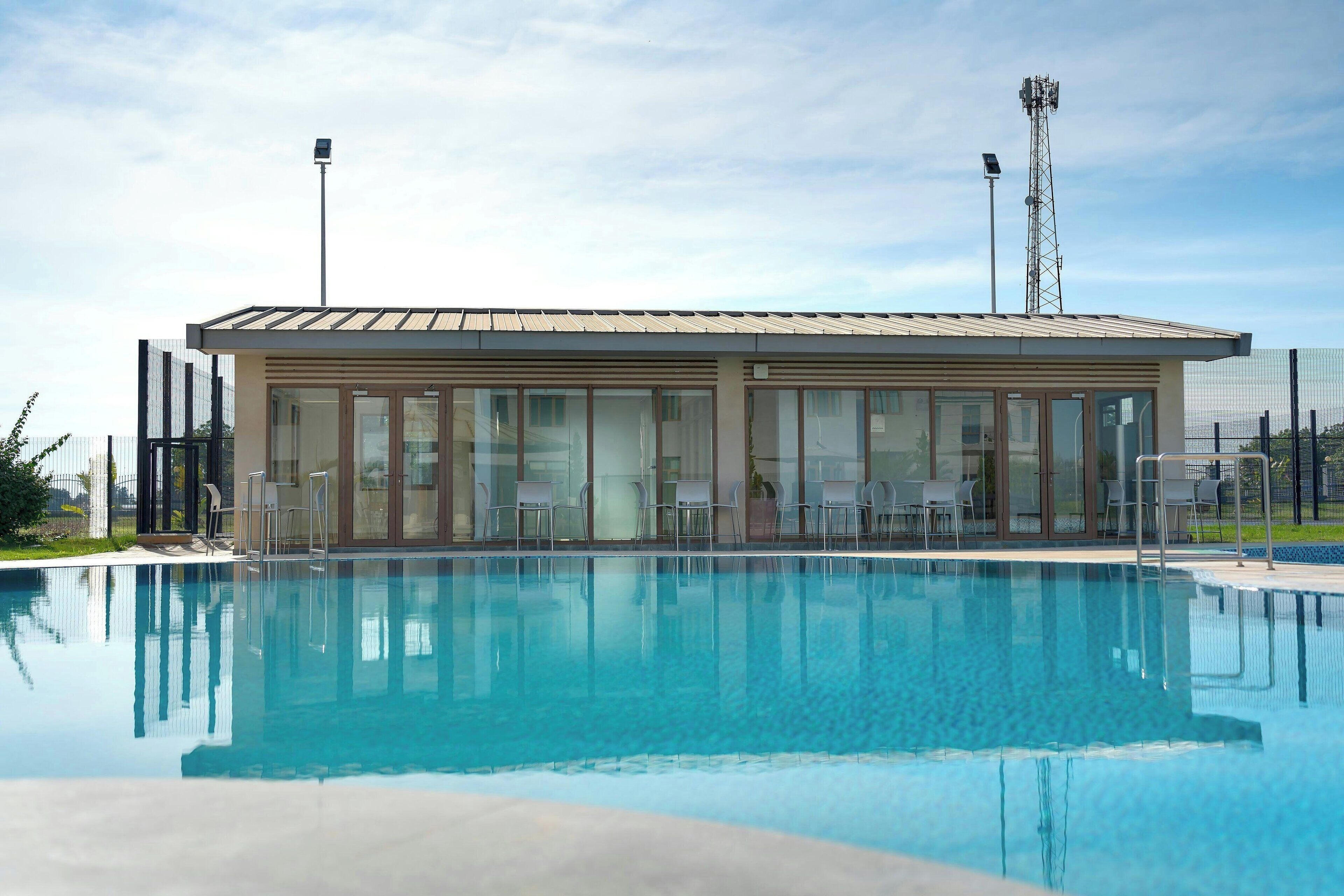Un bâtiment moderne avec une piscine devant.