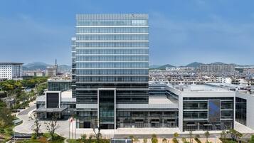 Un edificio moderno con fachada de vidrio y el nombre "FOUR POINTS" en la parte superior.