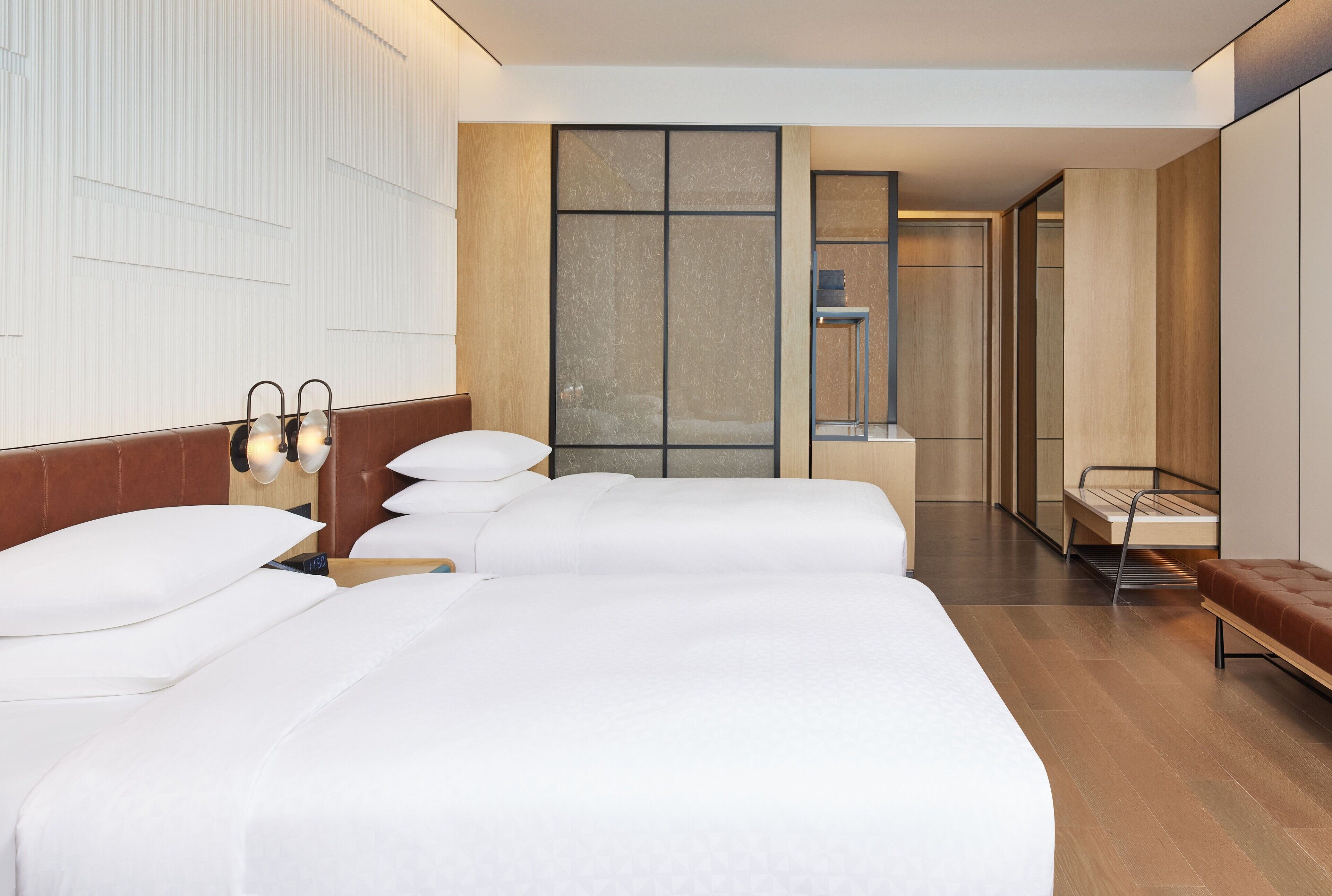 Una habitación de hotel con una cama grande, mesitas de noche y una zona de estar.