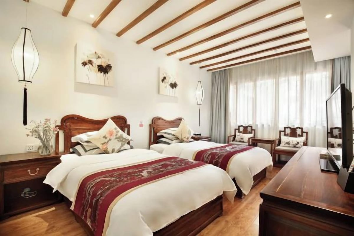 Una habitación de hotel con dos camas, un escritorio y una televisión.