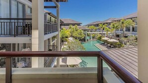 Un hôtel doté de nombreux balcons donnant sur un espace piscine.