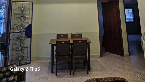Comedor con candelabro, techo de madera y una mesa con sillas.