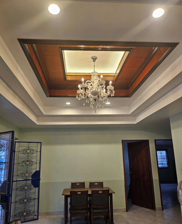 A dining area with a chandelier, wooden ceiling, and a table with chairs. - Room in Guest Room - Room 2 in a Superb House in Exceptional City Center (Pattaya)