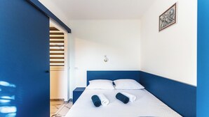A hotel room with a bed, two pillows, and two rolled towels. - Glorija Riverside Retreat Near Olimje (kozje)