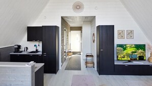 Een moderne keuken met donkere kastjes, een ingebouwde oven en een koffieapparaat.