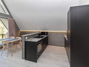 Una cocina moderna con horno integrado, microondas y cafetera.