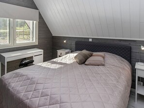 Un dormitorio con una cama, un escritorio y una mesita de noche.