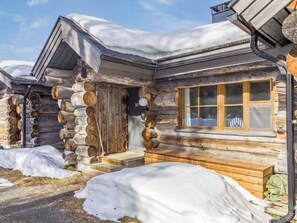 Eine Holzhütte mit Holztür, Fenster und Schornstein.