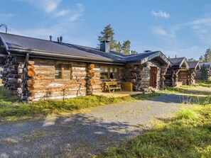 A log cabin with a porch and a chimney.