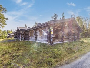 A rustic log cabin with a visible sign indicating a prohibition on parking.