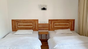 A room with two beds, each with a wooden headboard and white bedding. - Tianzishan Inn (Zhangjiajie)