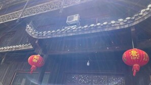 A traditional building with ornate wooden carvings and a curved roofline. - Tianzishan Inn (Zhangjiajie)