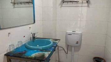 A bathroom with a blue sink, a mirror, and a white toilet.