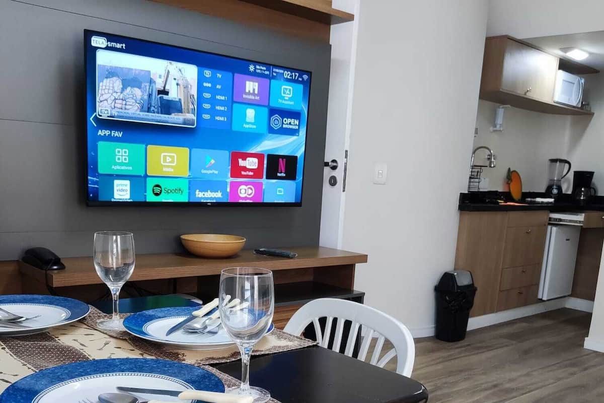Een moderne keuken met een flatscreen televisie aan de muur, waarop diverse apps worden weergegeven.