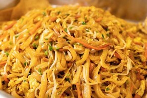 Gros plan d’un plat de nouilles sautées aux légumes, avec, éventuellement, des œufs.