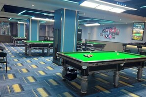 A pool table area with multiple tables, chairs, and a carpeted floor. - Yihe Hotel (Dongguan)