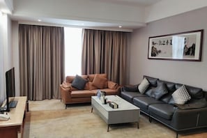 A living room with two sofas, a coffee table, a TV, and a framed picture on the wall. - Donglan Dongsheng International Grand Hotel (Wei Baqun Memorial Hall Cultural Square) (Donglan)