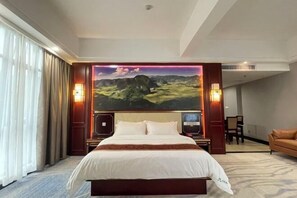 A hotel room with a large bed, a painting on the wall, and a sofa. - Donglan Dongsheng International Grand Hotel (Wei Baqun Memorial Hall Cultural Square) (Donglan)