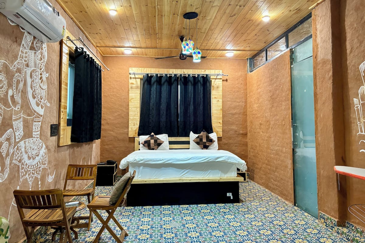 Ein Zimmer mit einem Bett, Holzmöbeln, einem Deckenventilator und Fliesenboden mit Muster.