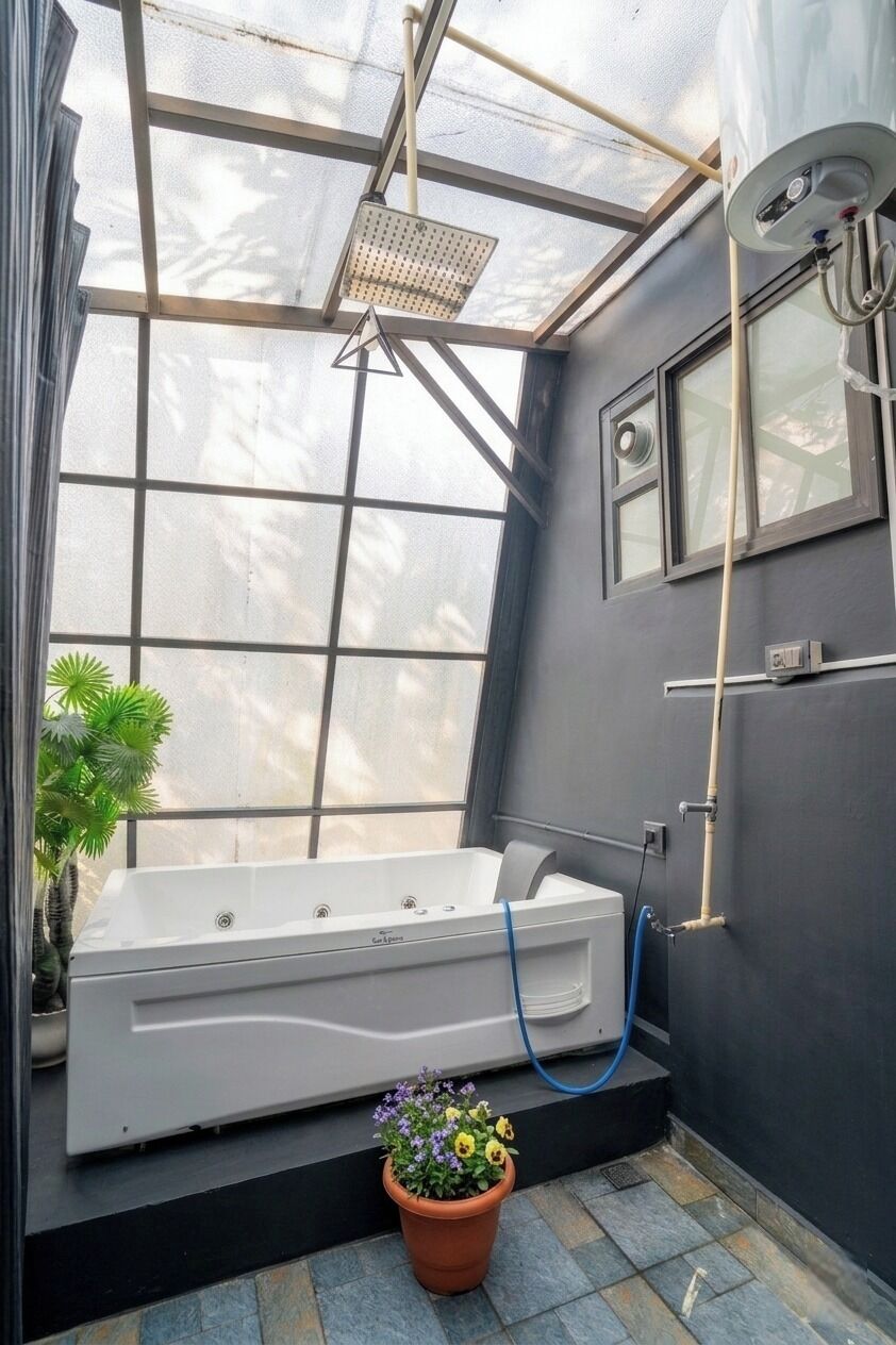 A small, enclosed bathroom with a bathtub, a shower, and a window.