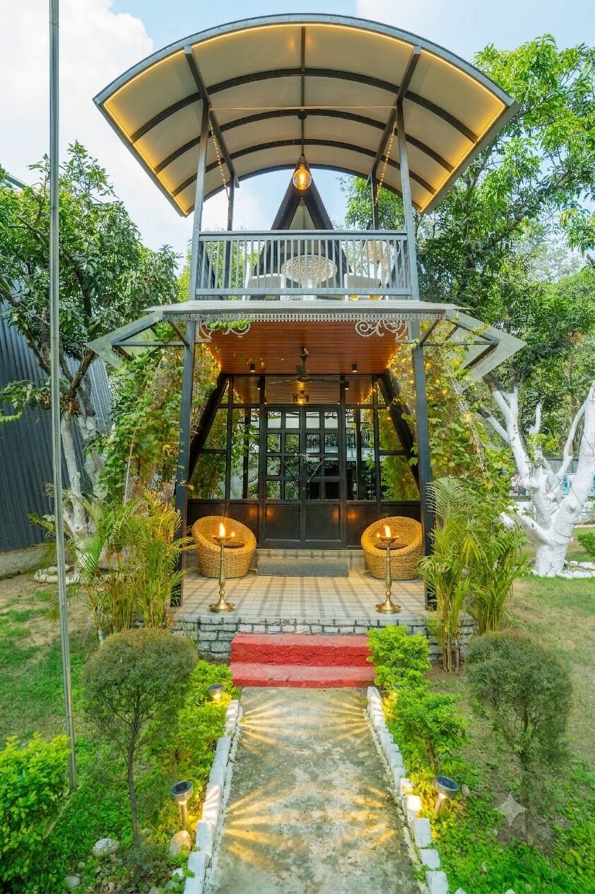 A two-story structure with a covered balcony, a central light fixture, and a red carpet leading to the entrance.