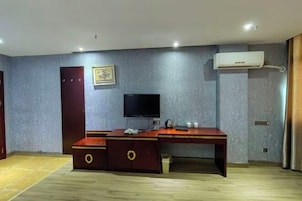 Una habitación con escritorio, televisión, armario y aire acondicionado.