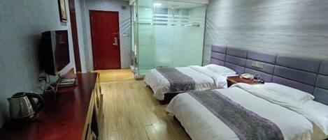 Habitación de hotel con dos camas, un escritorio de madera, un televisor y una puerta roja.