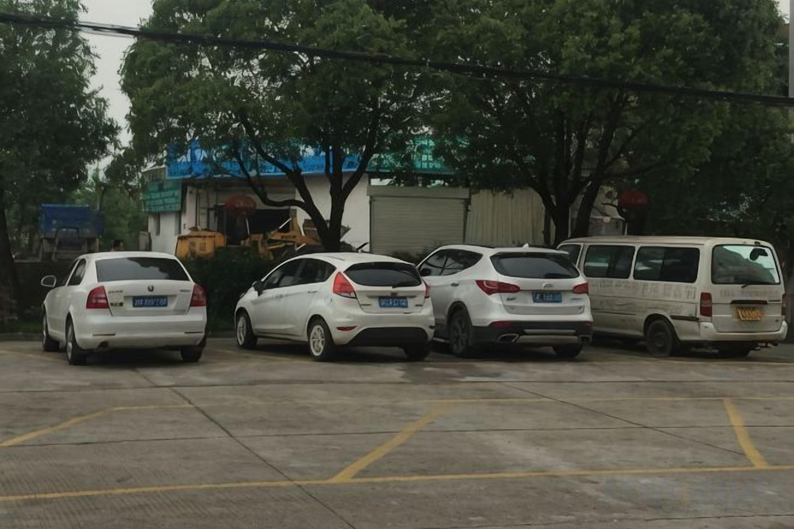 A parking lot with several cars and a white van.