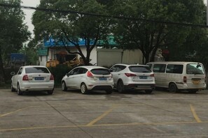 Un estacionamiento con varios coches y una camioneta blanca.