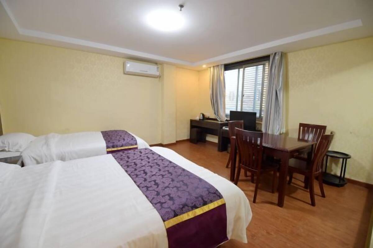 Habitación de hotel con dos camas, un escritorio y una mesa de comedor.