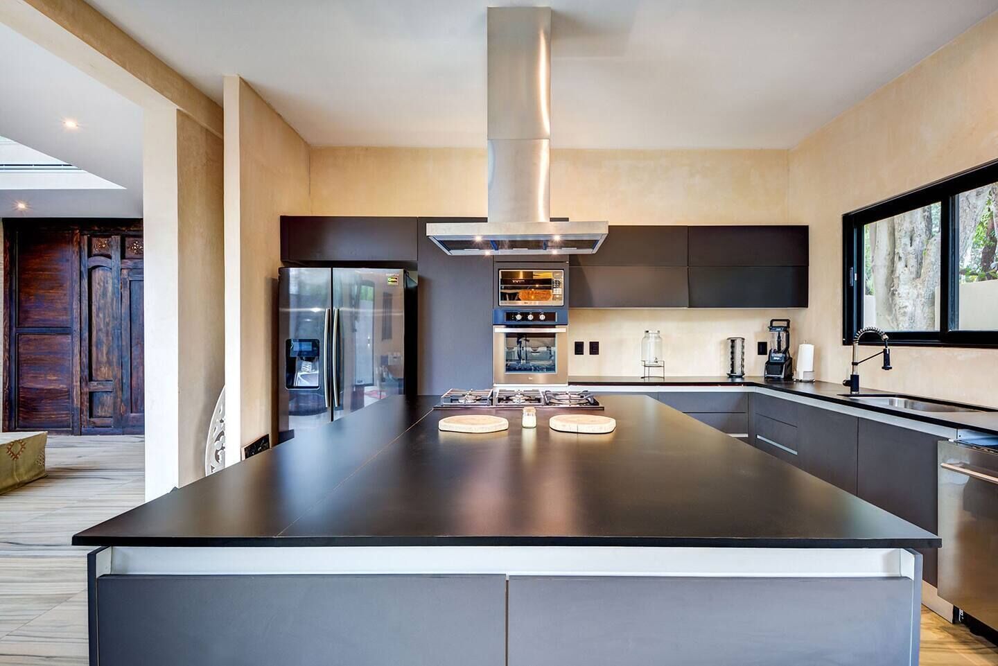 A modern kitchen with a large island, stainless steel appliances, and a sleek design.