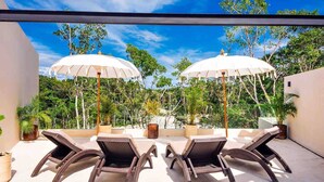 A rooftop terrace with two lounge chairs and two umbrellas, surrounded by lush greenery and trees. - Tulum Dream Villa: Designer Luxury Near The Beach (Tulum)