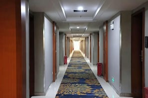 A hotel corridor with a patterned carpet, doors on both sides, and a light fixture on the ceiling. - Holiday Villas Airport (Guangzhou Baiyun International Airport) (Guangzhou)