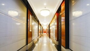 A long, well-lit hallway with glossy floors and modern decor. - Holiday Villas Airport (Guangzhou Baiyun International Airport) (Guangzhou)