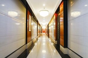 A long, well-lit corridor with reflective flooring, leading to a bright interior space. - Holiday Villas Airport (Guangzhou Baiyun International Airport) (Guangzhou)